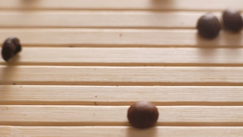 Roasted Coffee Beans Falling on the on the Table Surface in