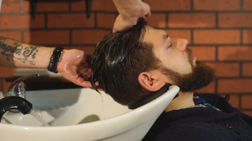 Hairstylist Washing Client's Hair in Barber Shop
