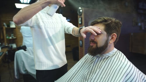 Hombre seguro de sí mismo visitando estilista en barbería.