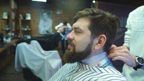 Confident Man Visiting Hairstylist in Barber Shop.