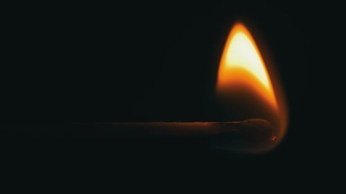 Burning Matchstick Ignites in Dark Environment Close Up
