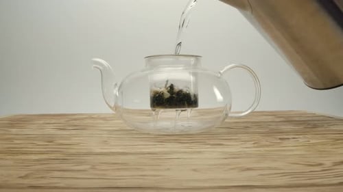 Hot Water Being Poured Into Glass Teapot