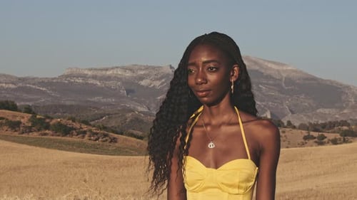 Campos abertos e montanhas e mulher bonita em pé no meio