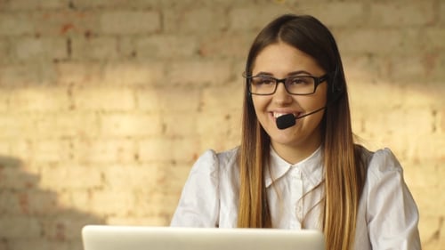 Schöne lächelnde Brünette arbeitet im Call Center