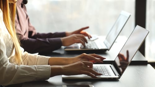 a Man and a Woman Working at a Computer in the Center of the Number