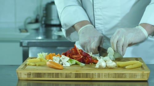 Chef Expertly Slices Vegetables in a Commercial Kitchen