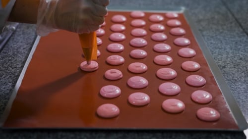 Making Macarons: Piping Pink Batter onto Baking Sheet
