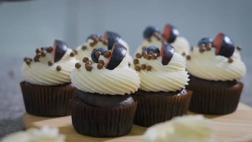 Cupcakes Topped With Blueberries and Brown Candies