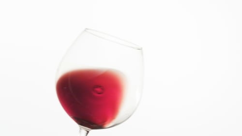 Red Wine Swirling in Glass on White Background