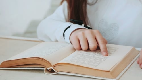 The Hand of a Little Girl Leads of the Book Page