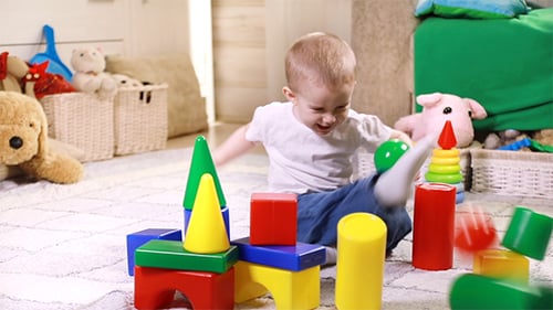 Child Playing with Colorful Building Blocks on Rug
