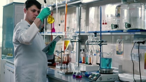 Scientist Working with Beakers in a Bright Laboratory