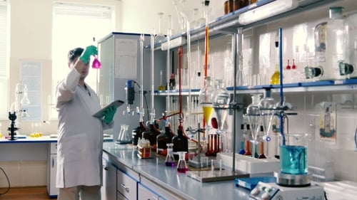Young Adult Scientist Working in Lab with Beakers