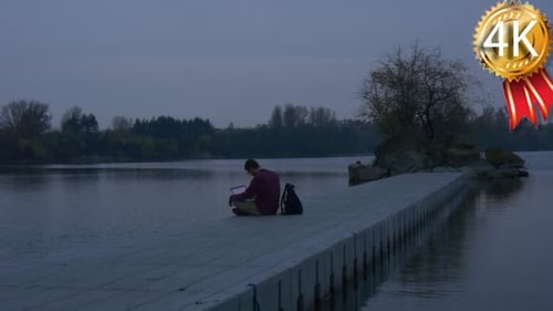 Freelancer Works on Laptop Man at the River Stony