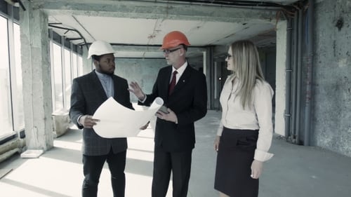 Construction Team Reviewing Plans and Shaking Hands