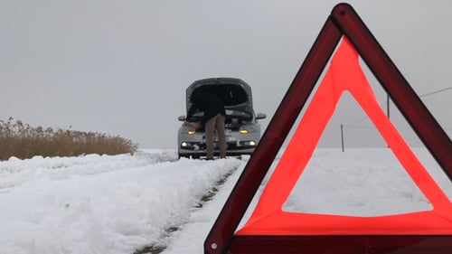 Warning Triangle and Car Trouble on Snowy Road