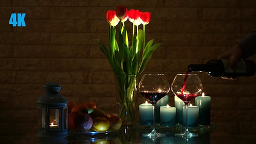 Pouring Wine with Candles and Red Tulips