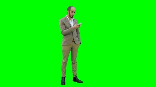 Businessman Using Mobile Phone on a Green Screen, Chroma Key.