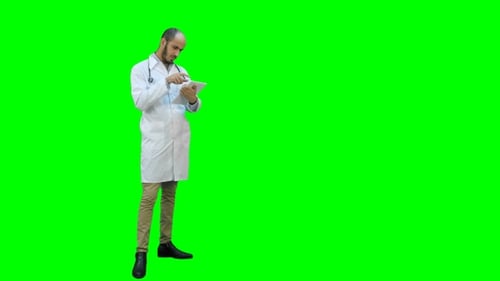 Young Male Doctor Using Digital Tablet on a Green Screen, Chroma Key.