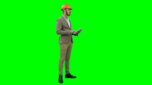 Engineer in Helmet Carrying Out Inspection Using Tablet on a Green Screen, Chroma Key.
