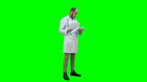 Male Doctor Checking Medical Documents on a Green Screen, Chroma Key.