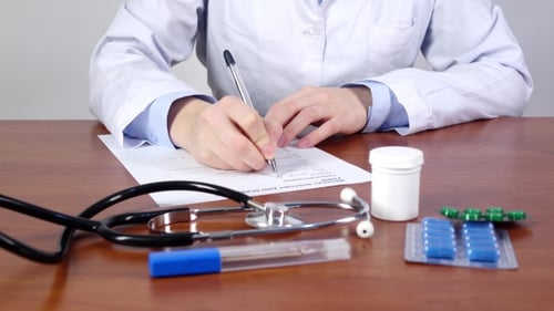 Doctor Writing a Medical History and Screening Form of the Patient