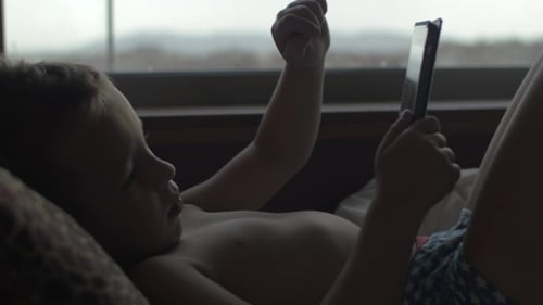 Child Using Digital Tablet in Bed