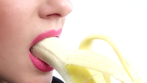 Woman eating a banana, close up