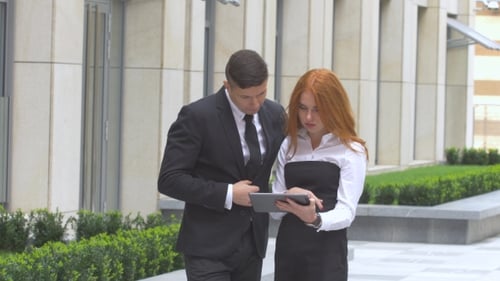 Business Colleagues Discussing Tablet Outside Office Building