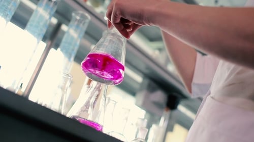 Swirling Pink Liquid in Erlenmeyer Flask in Lab