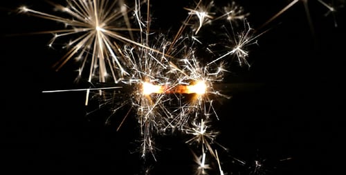 Glowing Sparklers Exploding and Burning Against Black Background