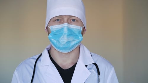 Junger Doktor blickt in die Kamera