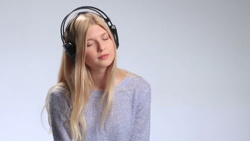 Blond Woman Listening to Music with Headphones Smiling