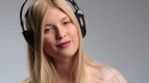 Playful Teenage Girl with Earphones on White