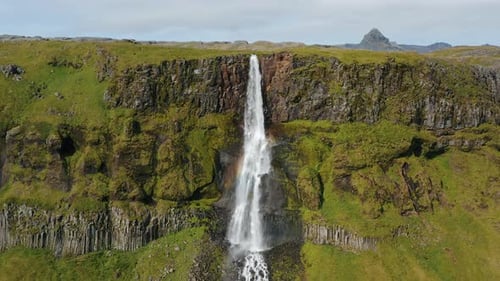 Aerial Drone Footage of Bjarnarfoss Waterfall with Its Green Cliffs in Western Iceland