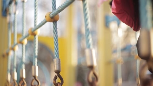 Child Walks on a Suspension Bridge on Playground