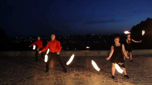Fire Dancers Performing Outdoors at Night