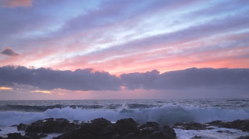 Waves Crashing on Rocky Shore at Sunset