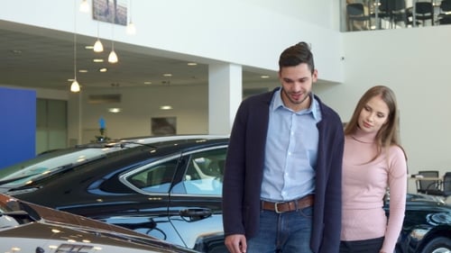 Young Couple Chooses Car at the Dealership