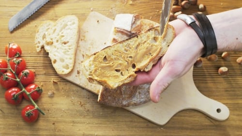 Hands Spreading Peanut Butter on Bread Slice