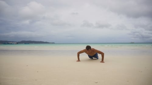 Man Doing Push-ups on the Beach