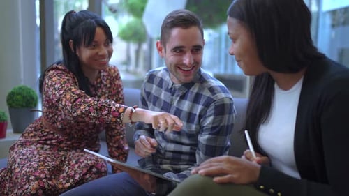 Friends Share a Tablet and Laugh Together