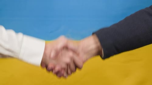 Business Handshake in front of Blue and Yellow Flag