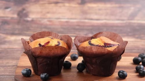 Hand Pick Blueberry Muffins on Table