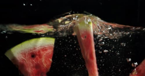 Watermelon Slices Splashing in Clear Water