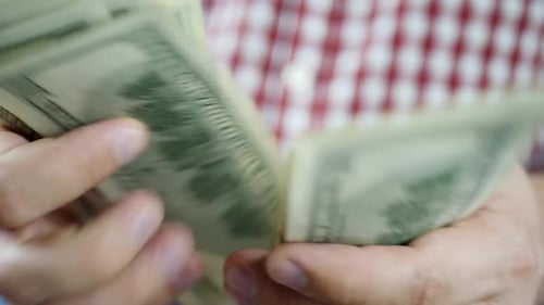 Hands Counting Stack of United States Currency