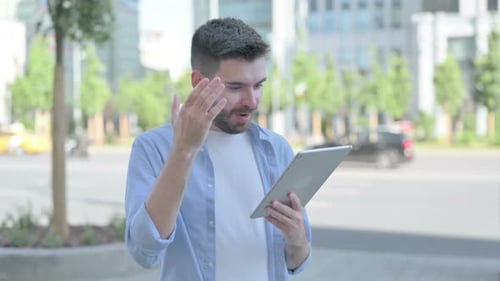 Man Using Tablet in Urban Setting Celebrates Success