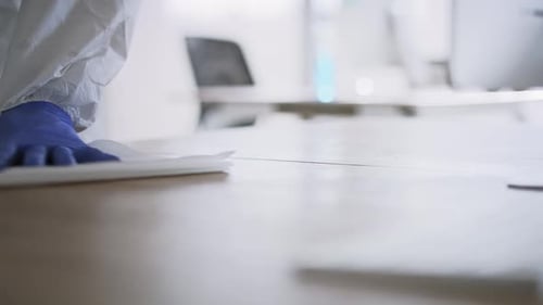 Close up video of human hands cleaning desk with disinfectant wipe