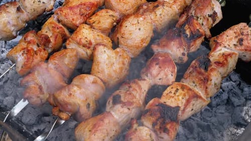 Schaschliks am Spieß werden auf dem Grill zubereitet. Rohes Fleisch gekocht auf Holzkohlegrill
