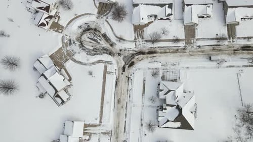 Luftbild von oben nach unten über ein Wohnviertel nach einem Schneesturm. Sand wirbelt auf der Straße.